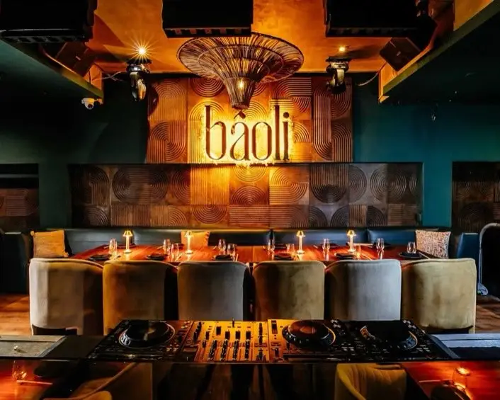 The BÂOLI dining room, with the illuminated sign and the DJ booth